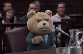 A Teddy Bear Is Giving A Speech In Front Of A Microphone In A Courtroom . GIF