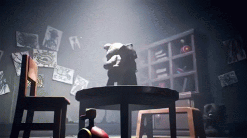 A Teddy Bear Is Sitting At A Table In A Dark Room GIF