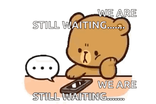 A Teddy Bear Is Sitting At A Table With A Cell Phone And A Speech Bubble Saying We Are Still Waiting .. GIF