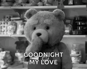 A Teddy Bear Is Standing In Front Of A Refrigerator And Holding Its Hand To Its Mouth . GIF