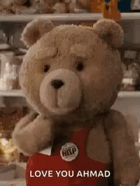 A Teddy Bear Is Wearing A Red Apron And Holding A Heart . GIF