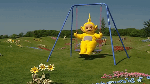 A Teletubbies Character Is Sitting On A Swing In The Grass GIF
