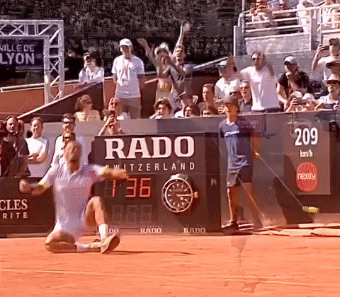 A Tennis Match Is Being Played In Front Of A Rado Sign GIF