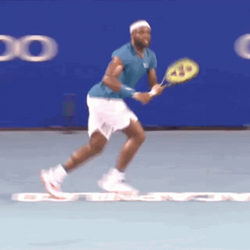 a tennis player in a blue shirt and white shorts holds a wilson racquet