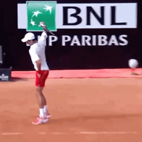 A Tennis Player Is Swinging A Racket In Front Of A Bnl Sign GIF