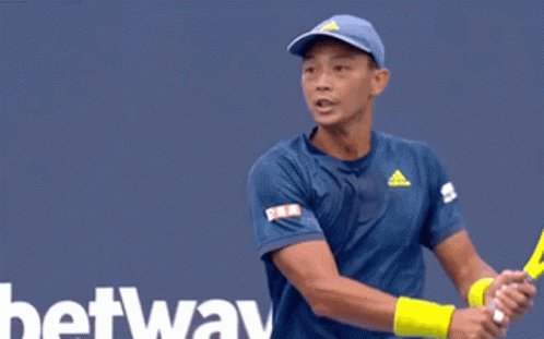 A Tennis Player Is Swinging A Racket In Front Of A Tau Sign GIF