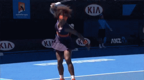 A Tennis Player Is Swinging A Racquet On A Blue Court With Kia Advertisements In The Background GIF