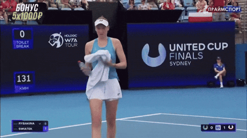 a tennis player is walking on a court in front of a united cup finals sign
