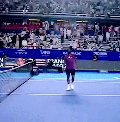 a tennis player on a court with a banner that says e pura