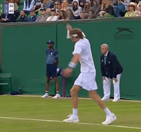 A Tennis Player On A Court With A Slazenger Logo On The Wall Behind Him GIF