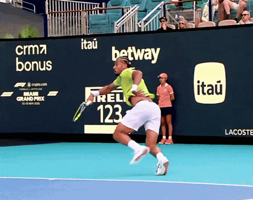 a tennis player on a court with an advertisement for itau on the wall