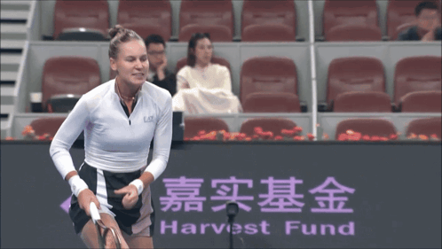 A Tennis Player Stands In Front Of A Harvest Fund Sign GIF