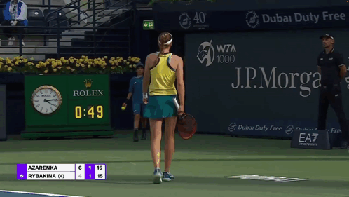 A Tennis Player Stands On A Court With A Rolex Clock In The Background GIF