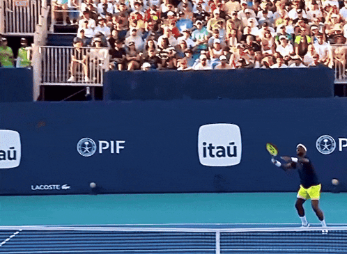 A Tennis Player Swings A Racquet In Front Of A Wall That Has Itau Written On It GIF