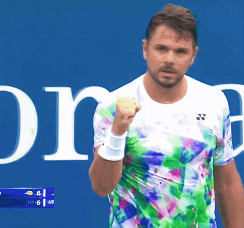 A Tennis Player Wearing A Colorful Shirt Holds Up His Fist GIF