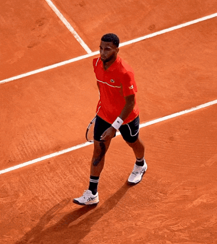 A Tennis Player Wearing A Red Shirt That Says Lacoste On It GIF