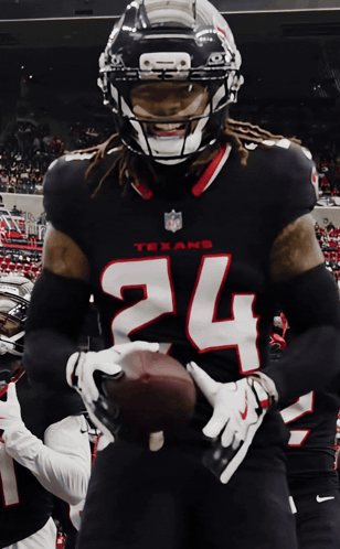 A Texans Football Player Is Holding A Football In His Hands GIF