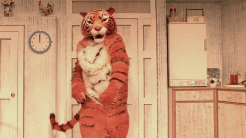 A Tiger Costume Is Standing In Front Of A Clock That Shows The Time As 1:15 GIF