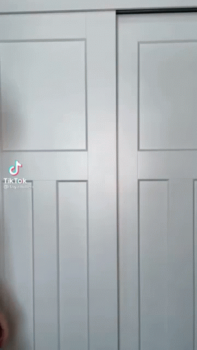 A Tiktok Video Of A Man Standing In Front Of A White Closet Door GIF