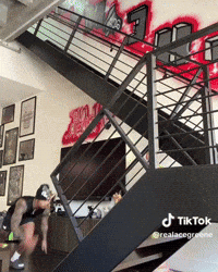 Person Jumping Down Stairs With Graffiti Wall GIF