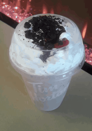 A Tim Hortons Cup With Whipped Cream And Oreo Cookies On Top GIF
