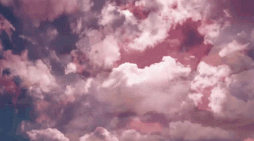 A Time Lapse Of Pink Clouds Moving In A Blue Sky GIF