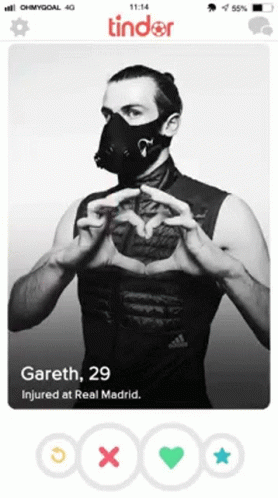 A Tinder Profile Of A Man Wearing A Mask And Making A Heart With His Hands GIF