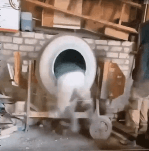 A Tire Is Being Used To Mix Concrete In A Mixer GIF