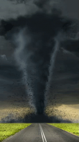 A Tornado Is Coming Down The Road In The Middle Of A Field GIF