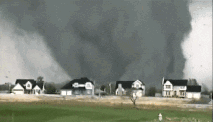 A Tornado Is Moving Through A Residential Area With Houses In The Background . GIF