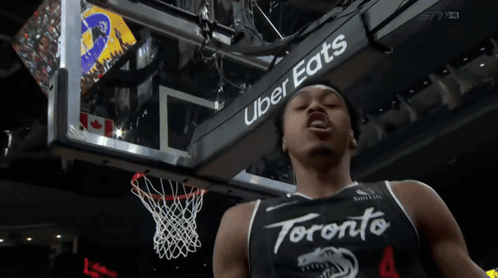 a toronto basketball player stands in front of a sign that says uber eats