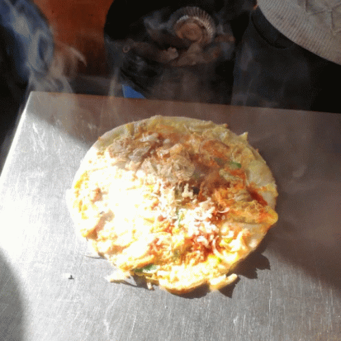 A Tortilla Is Being Cooked On A Stove Top GIF