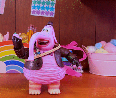 A Toy Elephant Is Standing On A Wooden Desk GIF