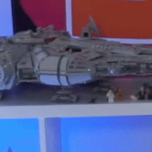 A Toy Falcon Sits On A Shelf Next To A Few Lego Figures GIF