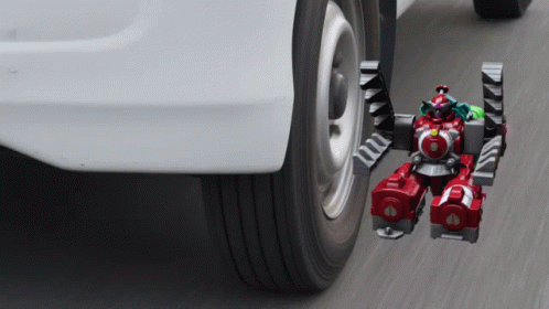 A Toy Robot Is Attached To The Side Of A Car GIF