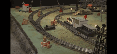 A Toy Train Set With Barrels And A Building With The Number 1 GIF