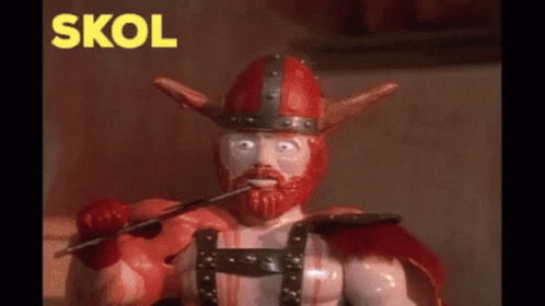 a toy viking with a sword in his mouth and the word skol in yellow behind him