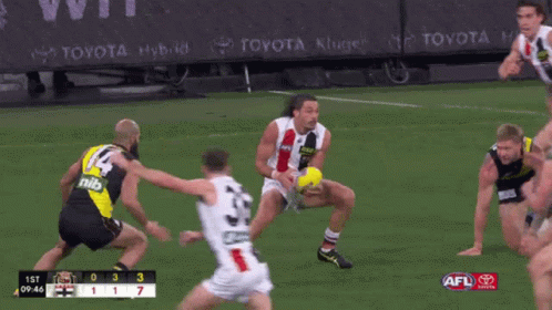 A Toyota Ad Can Be Seen Behind A Group Of Players On A Field GIF