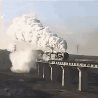 A Train Is Going Over A Bridge With Lots Of Smoke Coming Out Of It . GIF