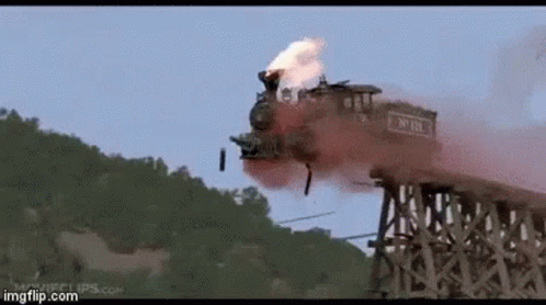 A Train Is Going Over A Wooden Bridge With Smoke Coming Out Of It GIF