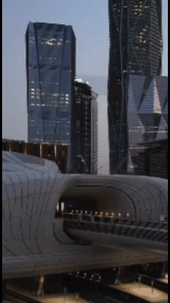 A Train Is Going Through A Tunnel In Front Of A City Skyline GIF