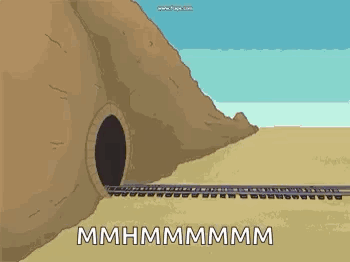 A Train Is Going Through A Tunnel In The Desert Next To A Mountain . GIF