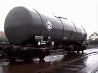 A Train With A Large Black Tank On The Side GIF