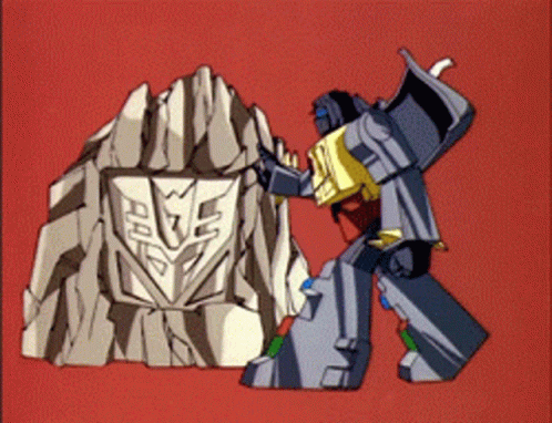 A Transformer Is Standing Next To A Rock With A Shield On It GIF