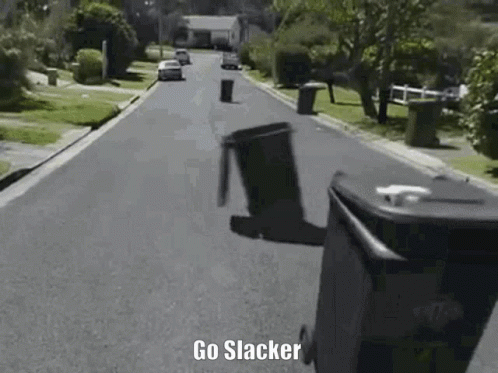 A Trash Can Is Flying Through The Air On The Side Of A Street . GIF