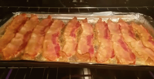 A Tray Of Bacon Is Sitting In An Oven GIF