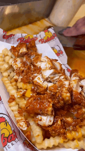 A Tray Of Fried Chicken And French Fries With Rubes Chicken Printed On It GIF