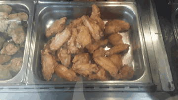 A Tray Of Fried Chicken Wings Sits On A Counter GIF