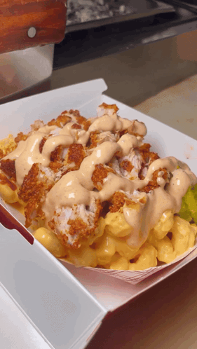 A Tray Of Macaroni And Cheese With Fried Chicken And Ranch Dressing GIF