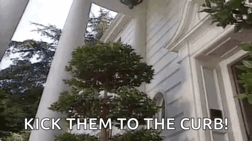 A Tree In Front Of A White House With The Words `` Kick Them To The Curb '' Written On It . GIF